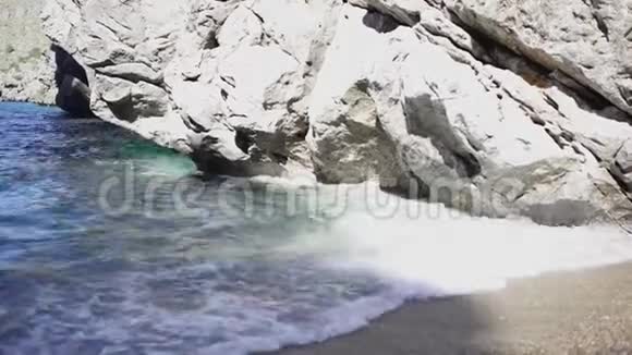 蓝色的小波浪在岩石和沙滩上破碎艺术在沙滩上翻滚在岩石上破碎的海岸小波浪的特写视频的预览图