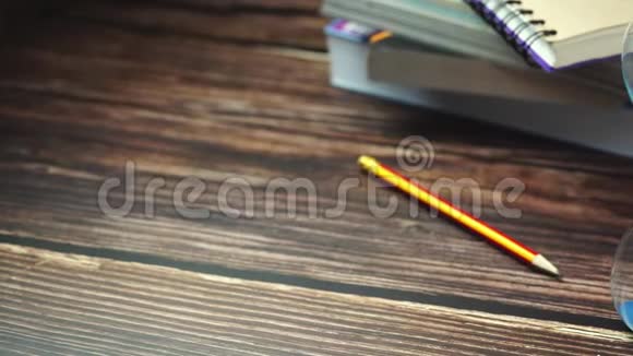 多莉沙漏铅笔和书堆放在木桌上视频的预览图