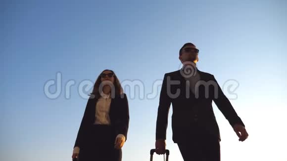 商务男女带着行李去机场年轻商人带着轮子的手提箱视频的预览图