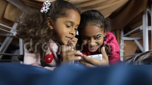微笑学龄前女孩浏览智能手机网络视频的预览图