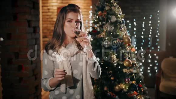 一个手里拿着火花的漂亮女孩正在喝香槟在圣诞节大笑视频的预览图