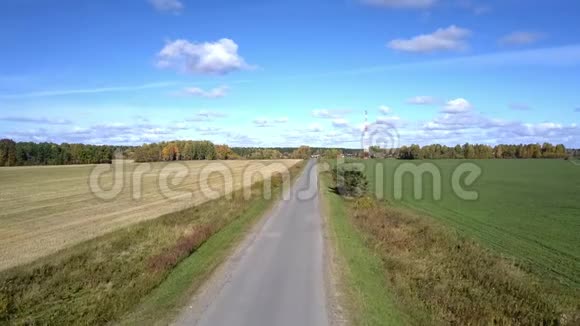 摄像机从田野间的道路上飞过蓝天视频的预览图