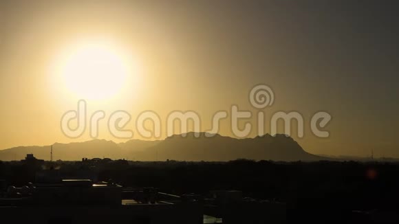 时间流逝的夕阳越过城镇和山脉视频的预览图
