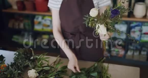 年轻女子花店布置漂亮的花艺构图视频的预览图