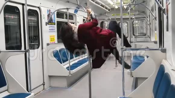 年轻女子在地铁里跳舞她跳着杆子挂在杆子上视频的预览图