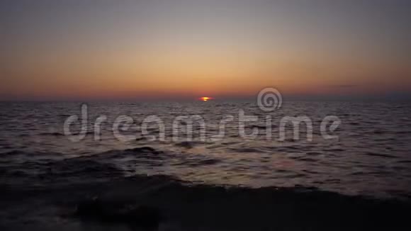 海上日落波浪在海岸的岩石上破碎破碎和飞溅视频的预览图