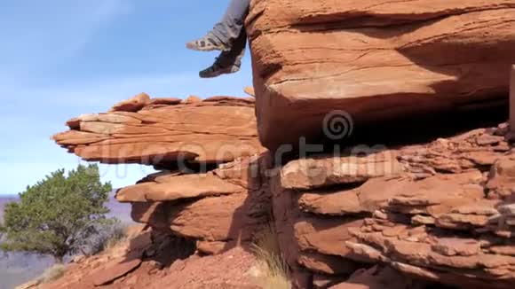 盘底向上的白种人女游客坐在大峡谷的石头上视频的预览图