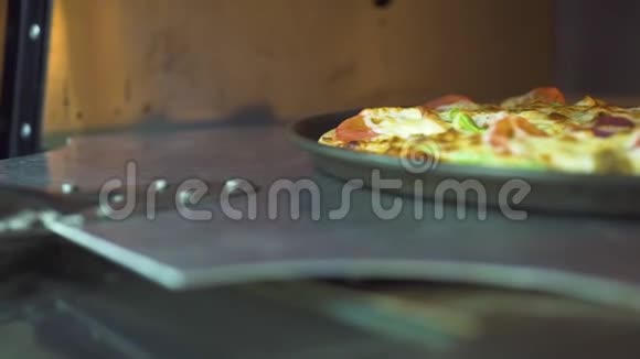 比萨略从比萨饼店的热烤箱里拿出厨房的铁铲把煮熟的比萨饼吃了带有脆皮的意大利比萨视频的预览图