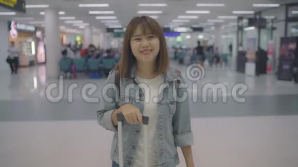 慢动作快乐的亚洲女人微笑着在国际机场的候机楼视频的预览图