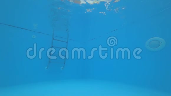 睁开眼睛的女孩在水下游泳在夏天像在蓝色游泳池里做手势视频的预览图