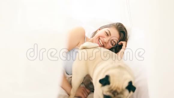 小狗早上在床上叫醒了他的情妇嘲笑漂亮的黑发女人录像片段视频的预览图