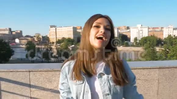 美丽的长发女孩在城市里唱日落背景特写视频的预览图