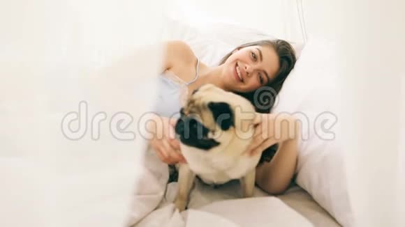 女孩和宠物在床上电镀早上好心情录像片段视频的预览图