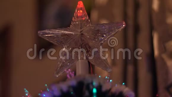 圣诞星在房间里闪耀着彩色的圣诞树闪耀着蓝色红色的灯光人工圣诞树视频的预览图