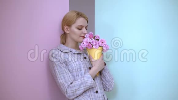 性感的女人嗅着一束玫瑰美丽的女人吸入花香视频的预览图