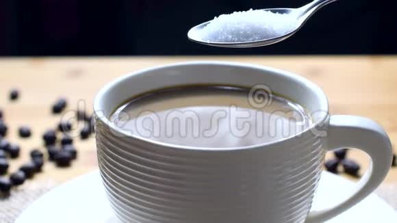 将糖倒入一杯咖啡中混合视频的预览图