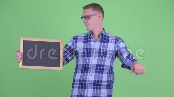 压力很大的年轻时髦男子举着黑板竖起大拇指视频的预览图