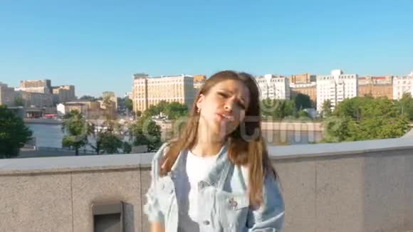 美丽的长发女孩在城市里唱日落背景特写视频的预览图