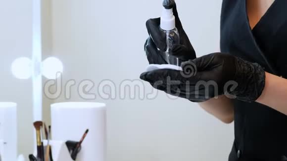 美容院特写镜头戴着黑色特殊手套的主人拿着一个棉垫用防腐剂洒上视频的预览图