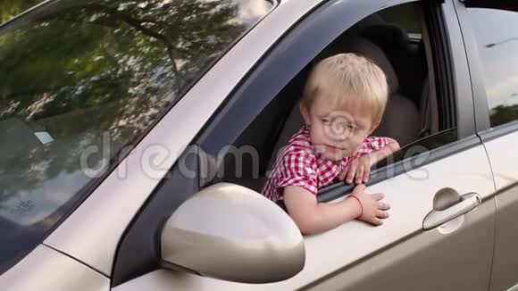 一个高兴的小男孩向车窗外望去视频的预览图