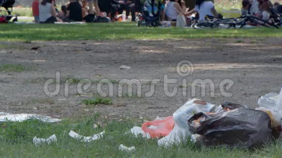 垃圾塑料袋放在人们旁边的公园里视频的预览图