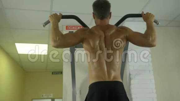 一个身体赤裸的年轻运动员在健身房里从事体力劳动用一个视频的预览图
