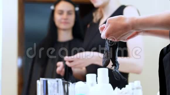 美容院特写时主人戴着黑色的特殊手套工作在镜子里反射的背景上视频的预览图