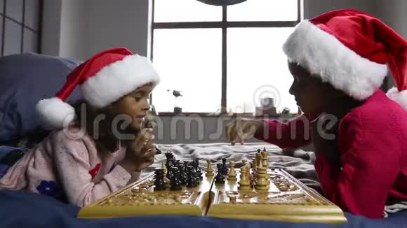 戴着圣诞帽的孩子下棋思考视频的预览图