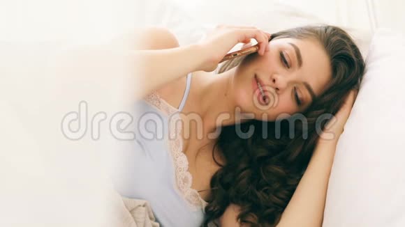 女人在床上用手机说话早上好对话录像片段视频的预览图