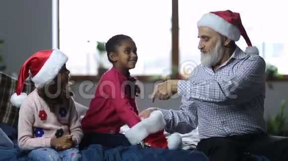 微笑的女孩和爷爷炫耀秘密圣诞老人视频的预览图