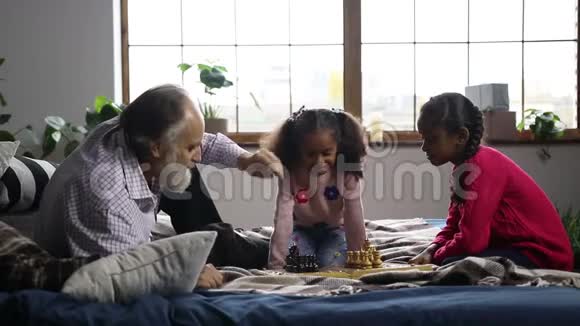一位老人正在和可爱的孙女下棋视频的预览图