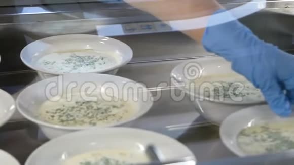库克把盘子和俄式冷菜汤放在一起快餐店里的奥克罗什卡盘子视频的预览图