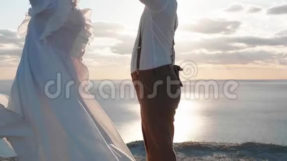 年轻漂亮的亚洲夫妇在悬崖上慢动作跳舞视频的预览图