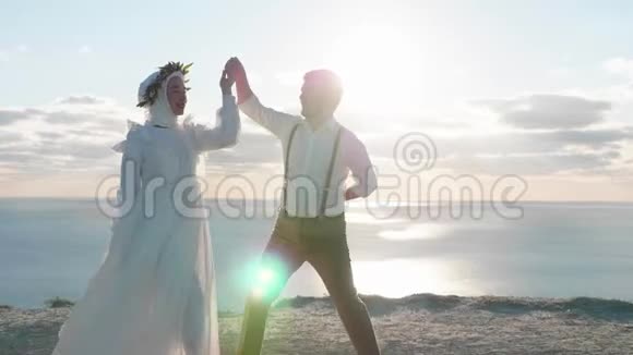 年轻漂亮的亚洲夫妇在悬崖上慢动作跳舞视频的预览图