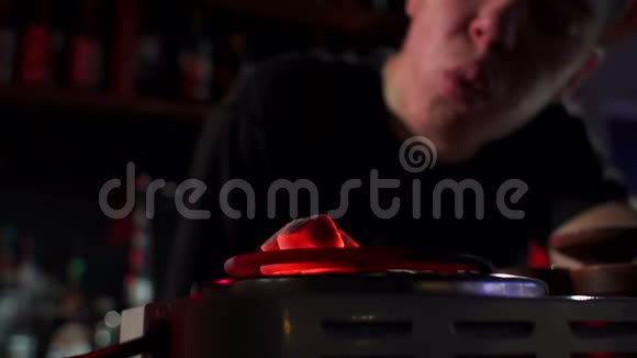 男调酒师在胡克酒吧吹煤的特写镜头视频的预览图