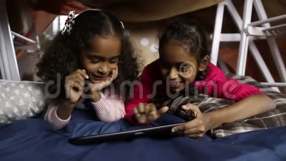 微笑的小女孩在做数码平板电脑视频的预览图