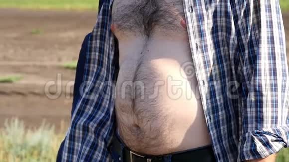 一个穿格子衬衫的男人的大毛肚一个男农民站在田里视频的预览图