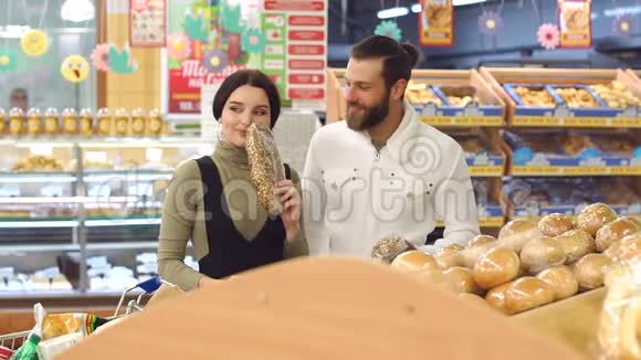 一对年轻夫妇在超市的肖像同时选择新鲜面包视频的预览图