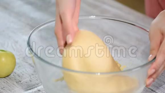 面包师用手在玻璃碗里揉面团做甜面包视频的预览图
