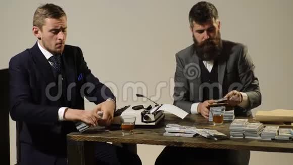 两个人坐在桌旁抽雪茄时算利润商人分利润视频的预览图