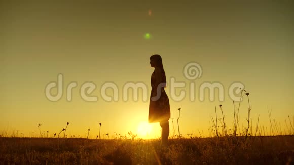 自由而快乐的长发女孩在金色的太阳日落时跳跃慢动作视频的预览图