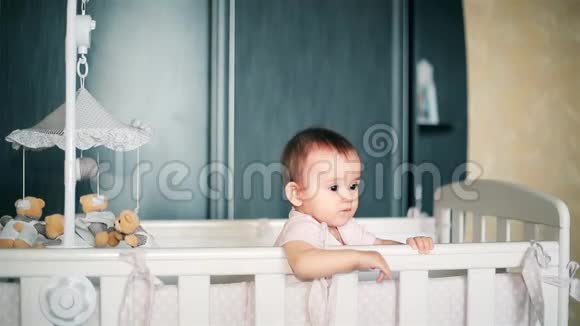 一个小女孩站在婴儿床上仔细观察一个高清的人视频的预览图