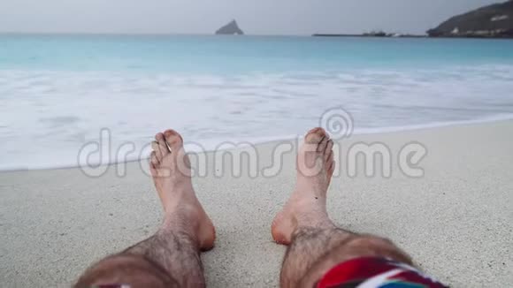 他的脚踩在沙滩上度假放松理念沙滩度假背景4k视频视频的预览图