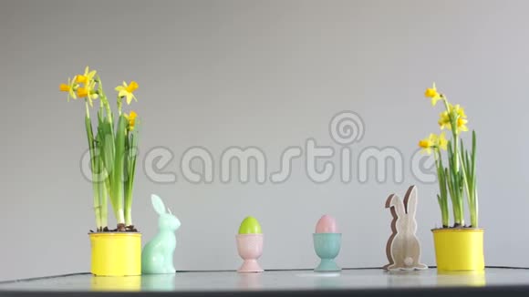 复活节装饰在桌子上孩子们手绑架装饰的鸡蛋盆栽水仙花兔雕像视频的预览图