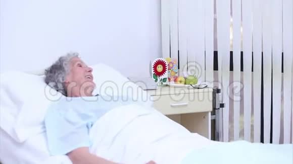 一位名叫塞琳的高级妇女在一位护士面前讲话她送了一束花视频的预览图