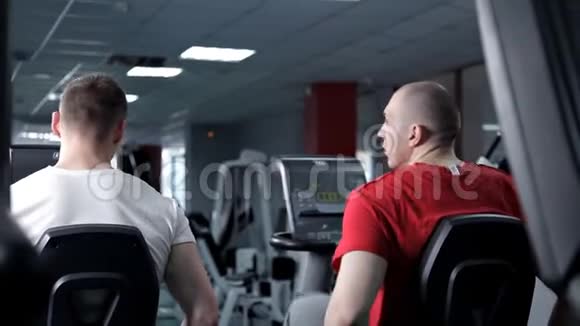健身男子在健身房里用一辆固定自行车工作保健培训视频的预览图