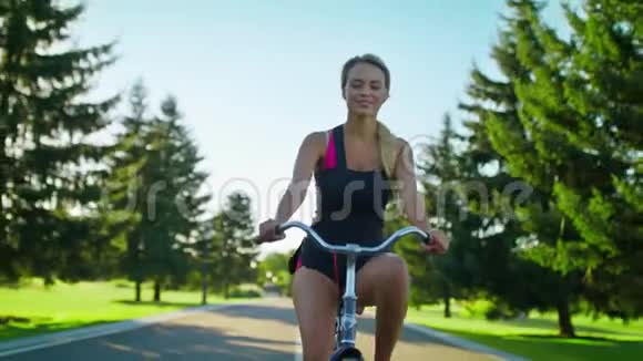 快乐的女人在夏天的公园里享受自行车骑行和挥手骑自行车视频的预览图
