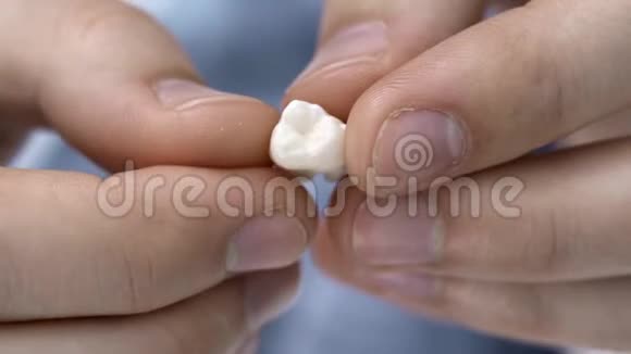 男性手中白色磨牙的特写镜头视频的预览图