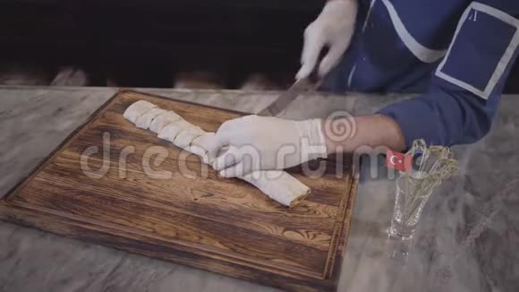 身着蓝色厨师制服的熟练男子在现代土耳其餐厅烹饪烤肉串厨师把烤串包在皮塔拉瓦什视频的预览图