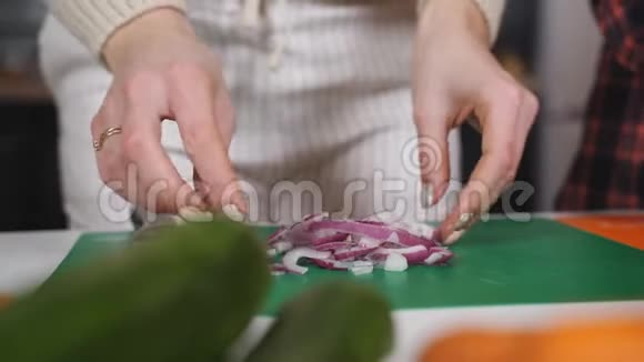 厨房里的两个女孩切红洋葱做沙拉视频的预览图
